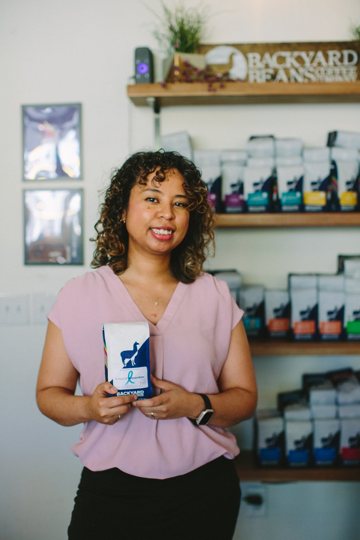 Image of a woman part of non-profit organization holding a coffee bag for a fundraiser.