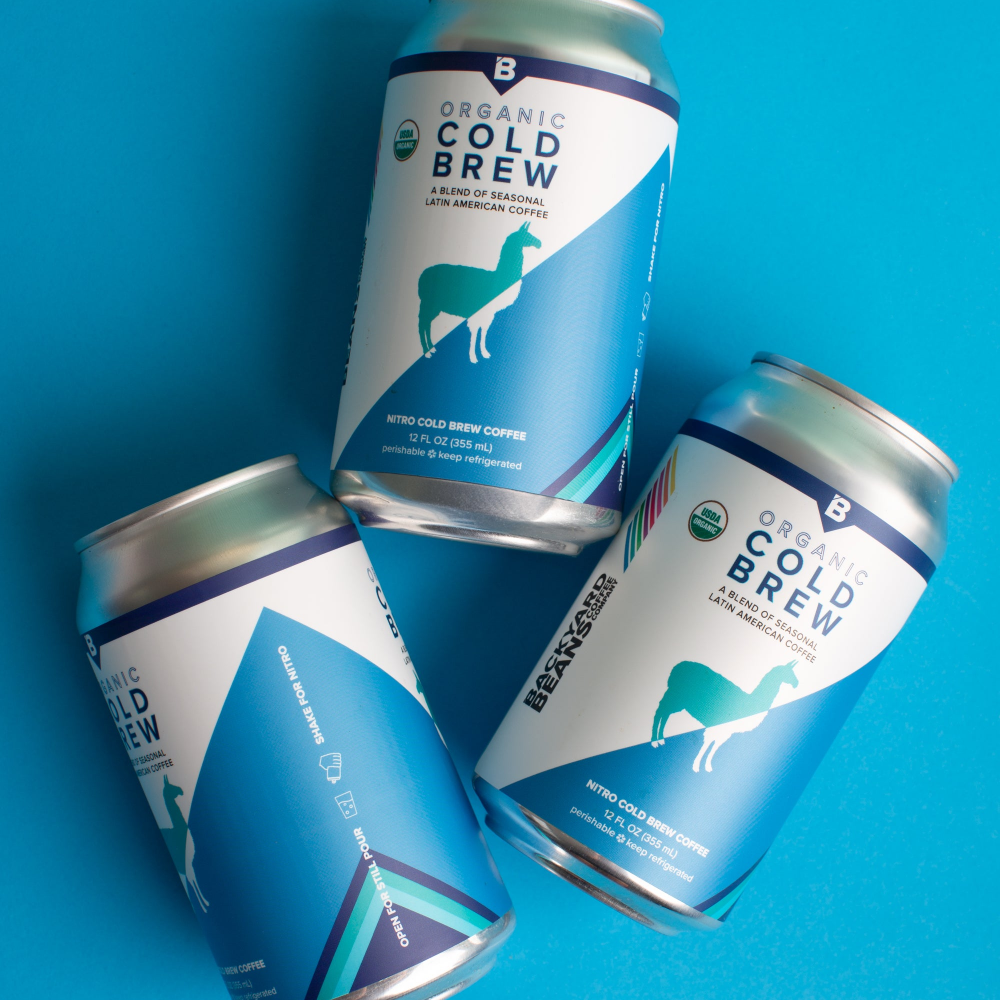 Three cans of Organic Cold Brew coffee on a blue background