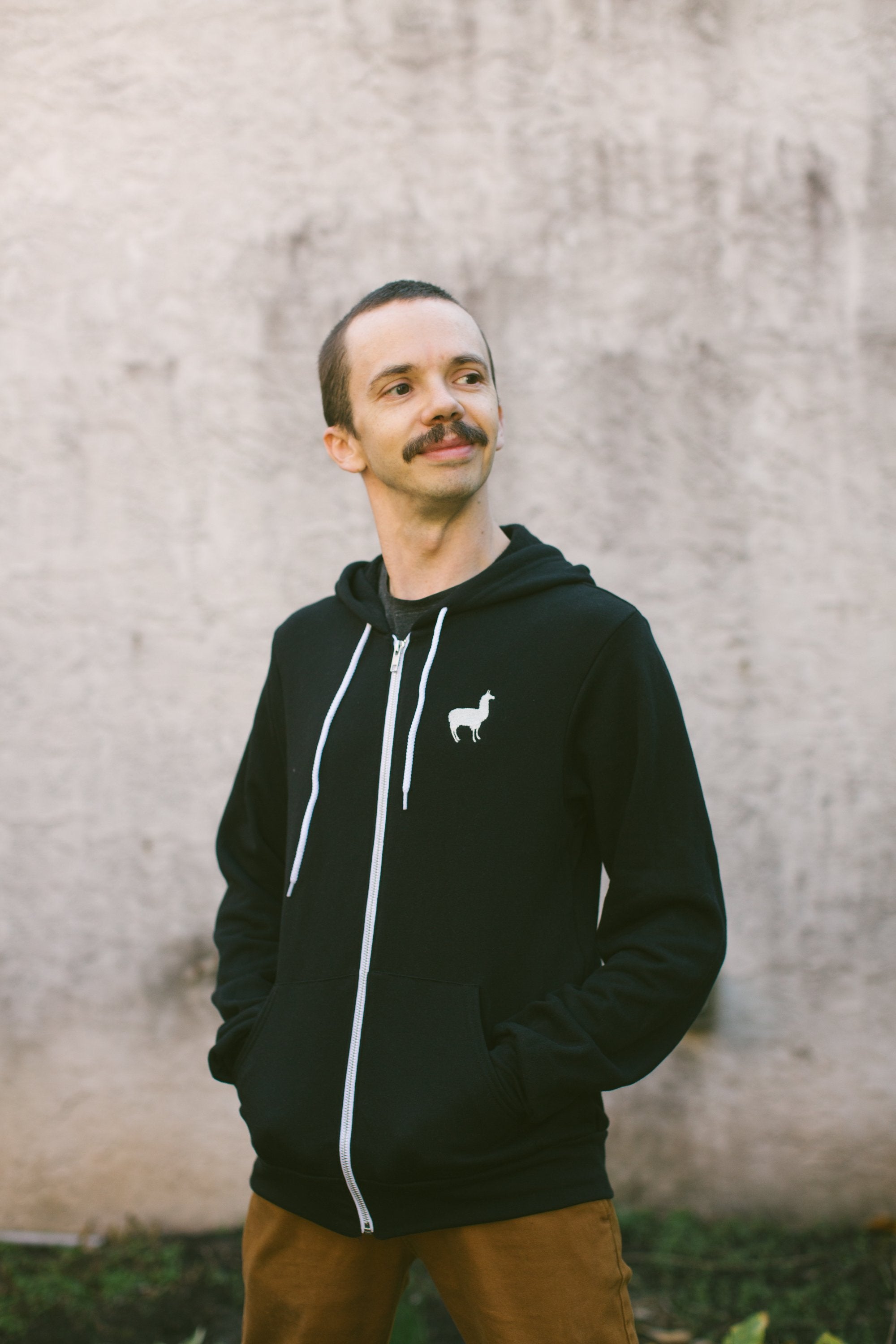 Image of man wearing Embroidered Llama Zip Up Hoodie in black.