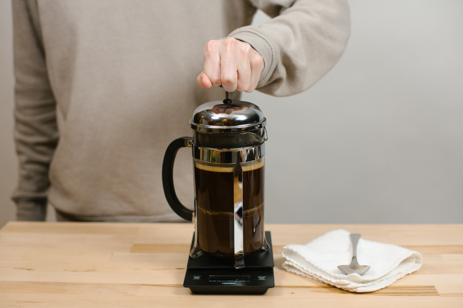Image of hand on French Press plunger.