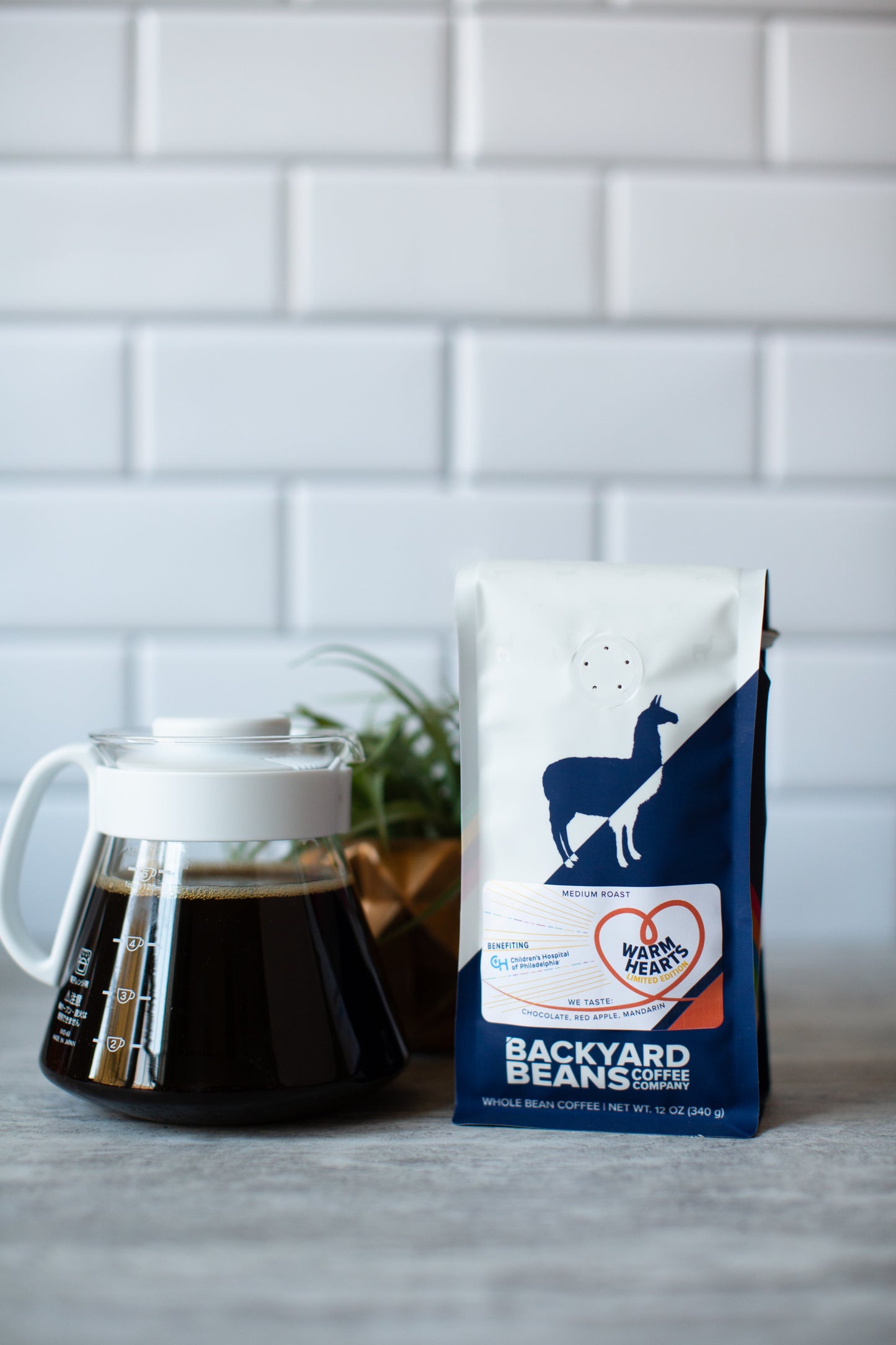 Image of coffee brewed next to Warm Hearts coffee bag.