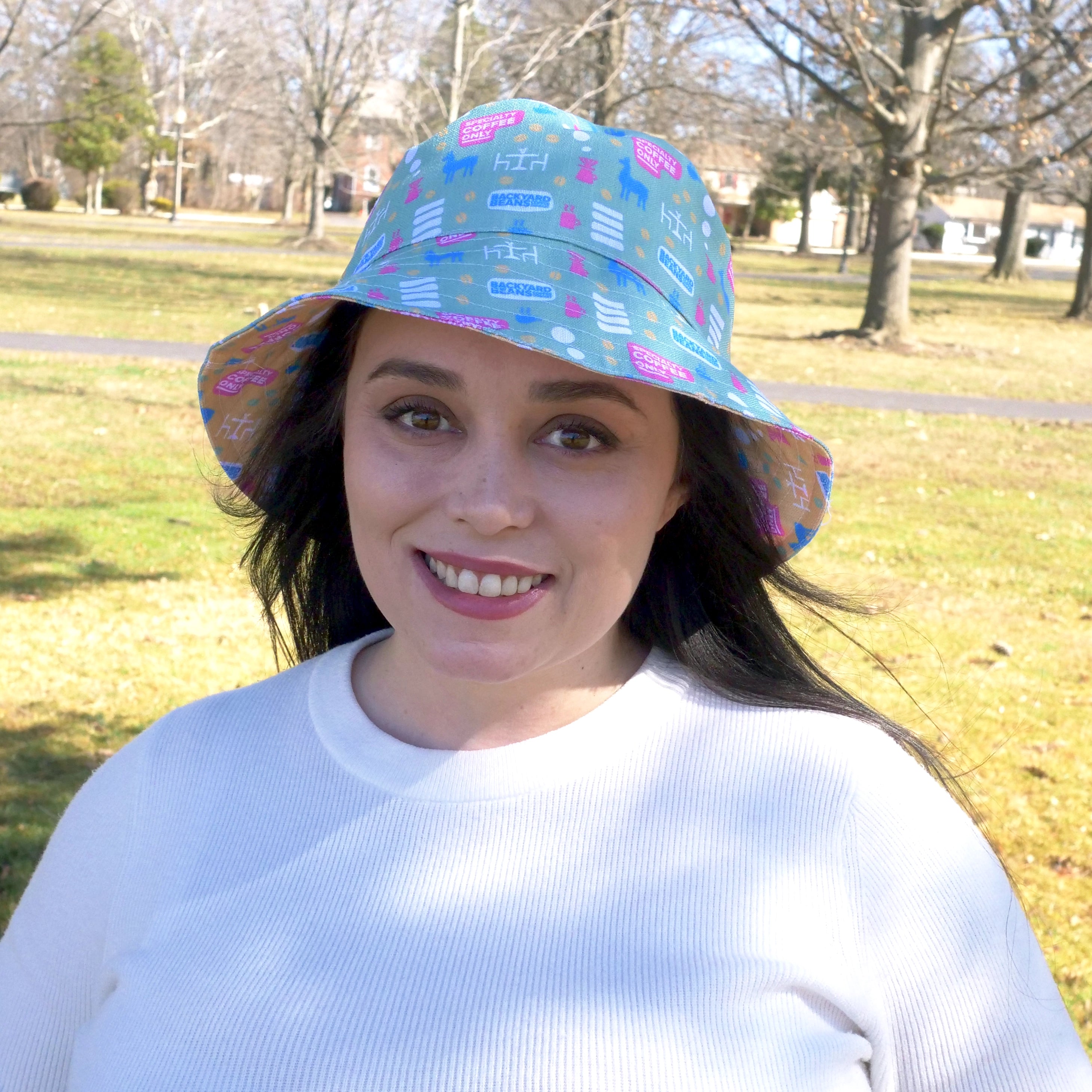 Woman wearing a colorful bucket hat in an outdoor setting