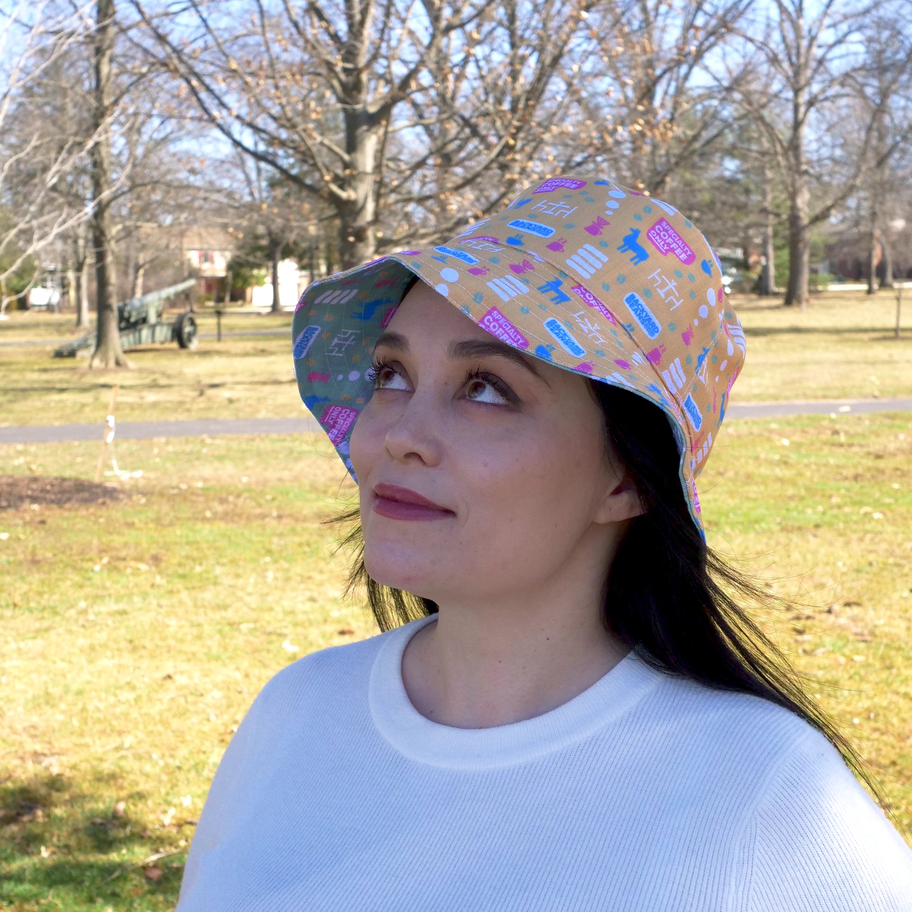 Woman wearing a colorful bucket hat in a park setting