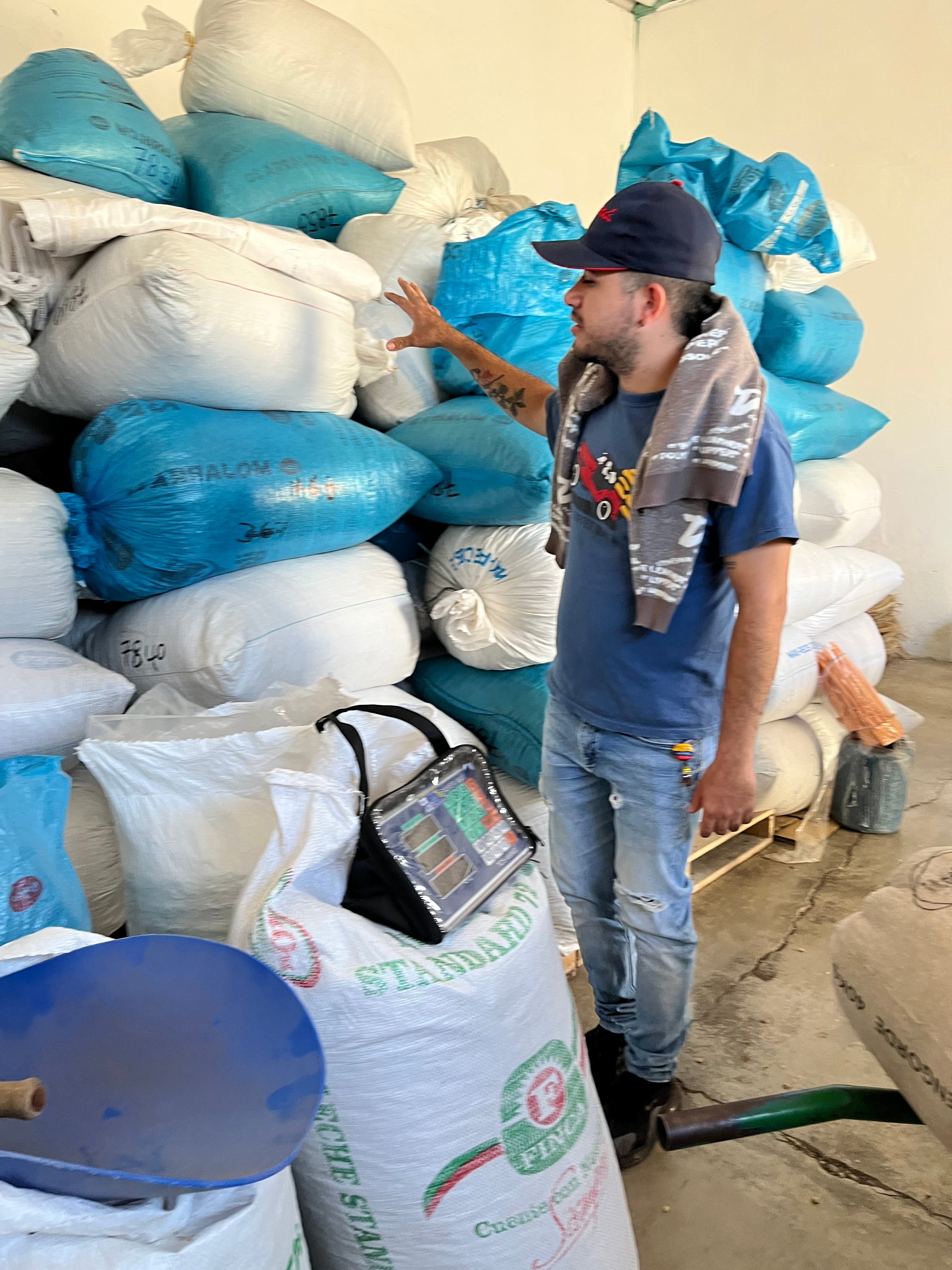 Person working with bags of coffee and a digital scale in an industrial setting