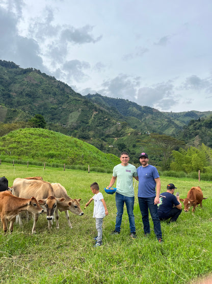 Image of Emmanuel Enciso with Bobby Wrigley in the cows pasture next to the washing station.