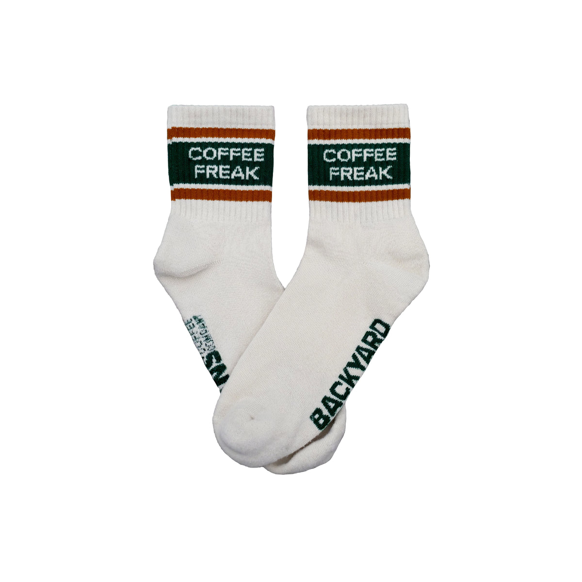 A pair of white crew socks with green and orange stripes at the cuff, featuring 'COFFEE FREAK' printed in white on a dark green band, and 'BACKYARD BEANS' printed in green along the sole of one sock.